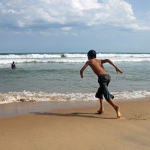 child running to water on beach