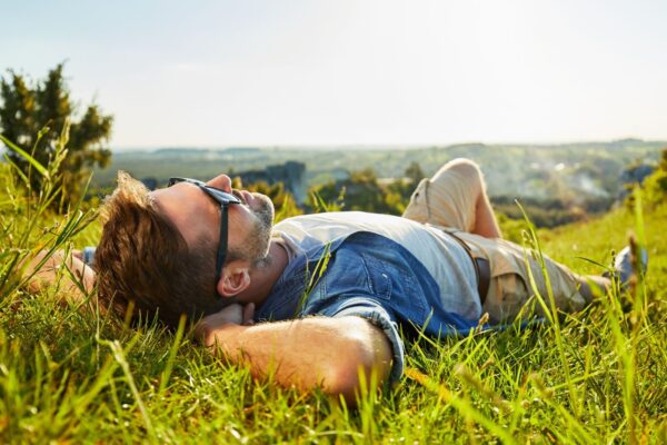 man lying in the sun on a hike
